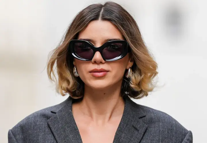 Mujer con gafas de sol y un moderno balayage pelo corto en tonos miel y castaño.