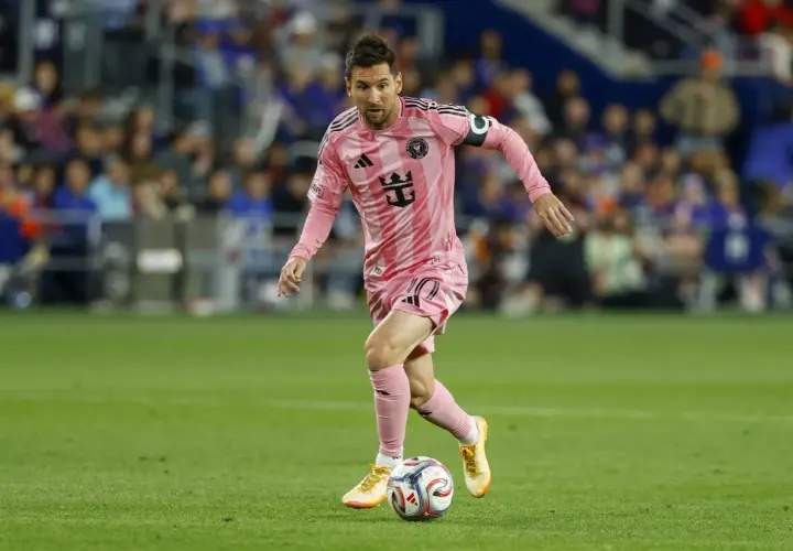 Lionel Messi w różowej koszulce Inter Miami drybluje piłką na boisku MLS.