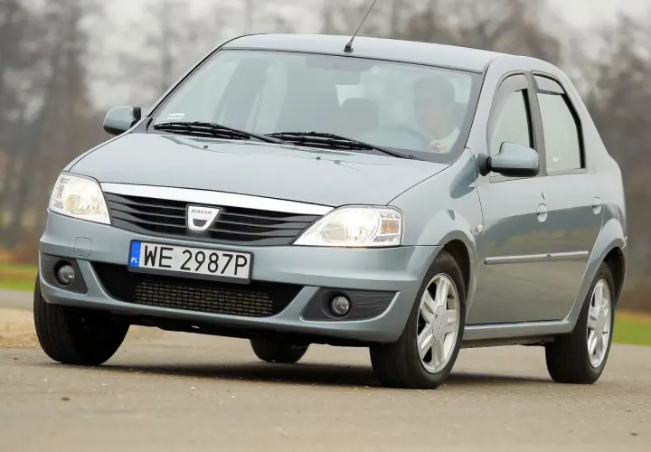 Szary Dacia Logan sedan z polskimi tablicami WE 2987P jedzie po drodze.