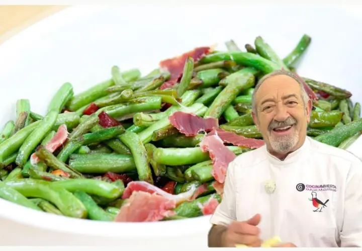 Un chef sonriente presenta un plato de judías verdes salteadas con trozos de jamón.