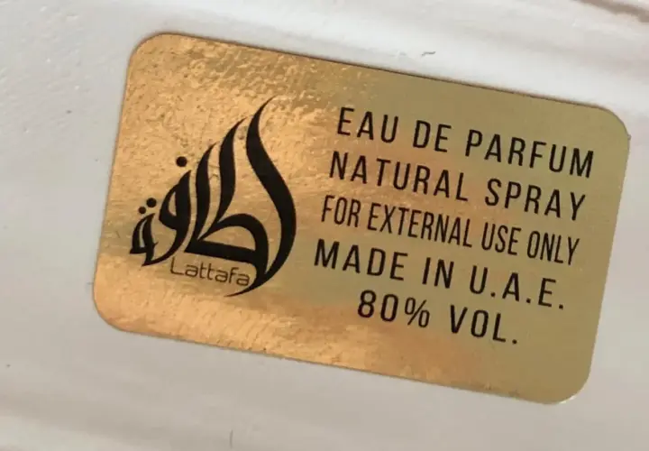 Złota naklejka z napisem Lattafa i logo. Woda perfumowana, spray naturalny, do użytku zewnętrznego, wyprodukowano w ZEA. Qaed Al Fursan Unlimited.