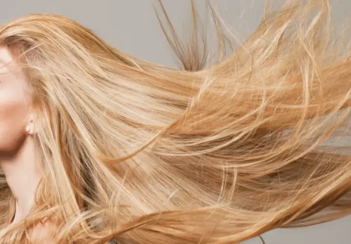 Mujer rubia con el pelo largo y suelto que parece que el pelo se aclara con el sol.