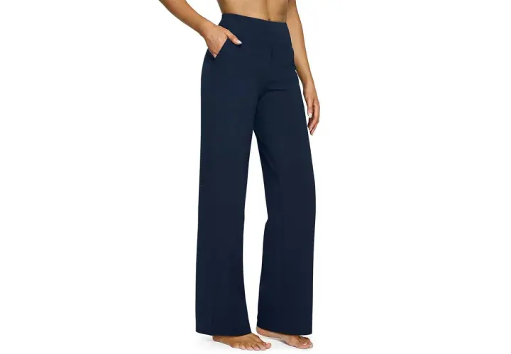 A person models navy blue yoga pants with a wide leg, perfect for hemming to achieve the ideal length for any activity.