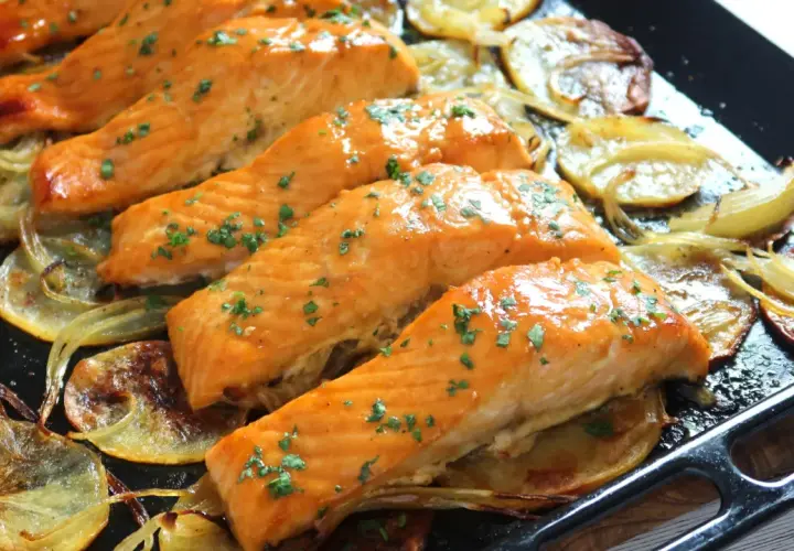 Filetes de salmón jugoso al horno con patatas y cebolla asadas.