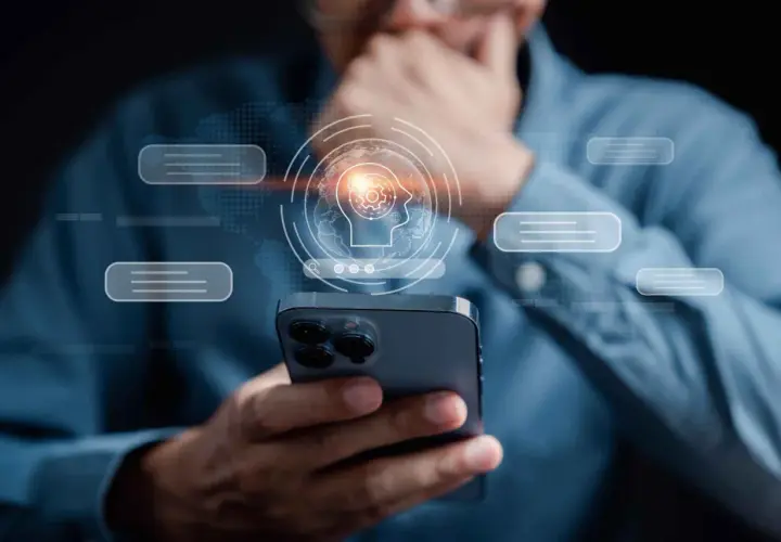 Mężczyzna trzyma smartfon, nad którym unosi się grafika mózgu z ikonami, symbolizująca sztuczną inteligencję napędzaną przez **samsung exynos**.