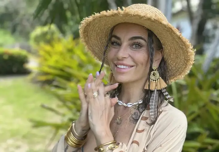 Kasia nastraja pozytywnie w słomkowym kapeluszu i boho biżuterii, uśmiecha się na tle zieleni.
