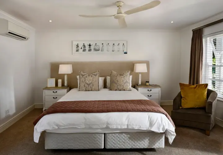 Luxurious hotel bedding layers, featuring crisp white sheets, decorative pillows, and a warm throw, invite a restful night's sleep.
