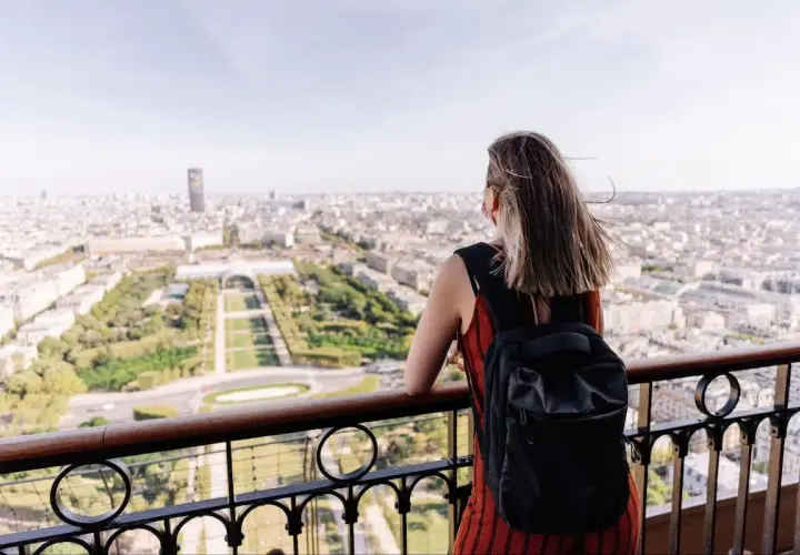 Kobieta z plecakiem podziwia panoramę Paryża. To idealny czwartek po francusku, pełen słońca i widoków.