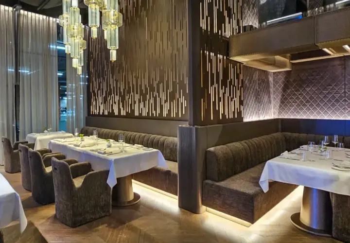 Eleganckie wnętrze restauracji w Poznaniu, z białymi obrusami i nowoczesnym designem. Idealne miejsce na odkrycie nowych restauracji w Poznaniu.