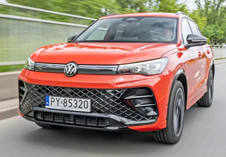 Nowy Tiguan w jaskrawym kolorze jedzie po drodze.