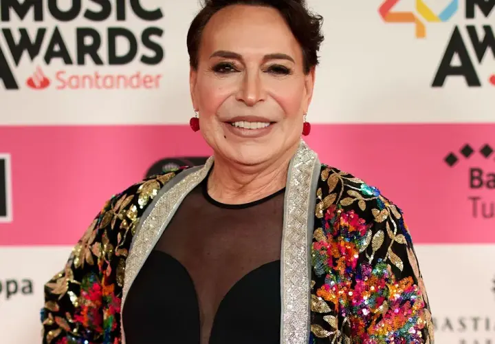 Benita Maestro Joao sonríe en la alfombra roja, luciendo una chaqueta colorida y brillante.