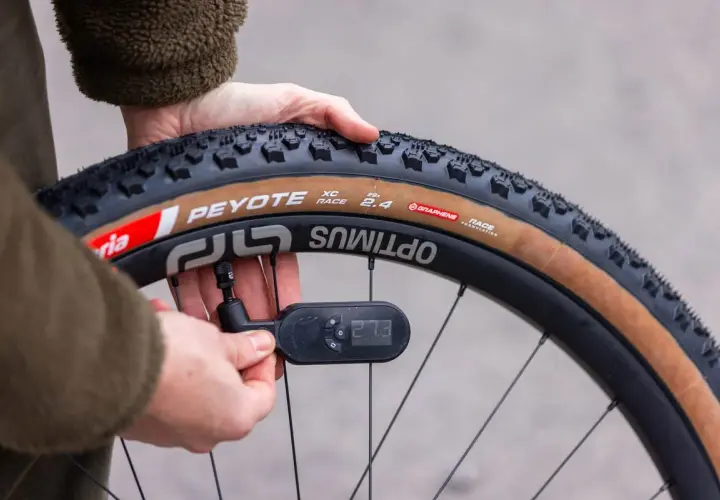 Checking how much air in bike tire. The gauge reads 27.3 PSI on a Peyote XC Race tire.