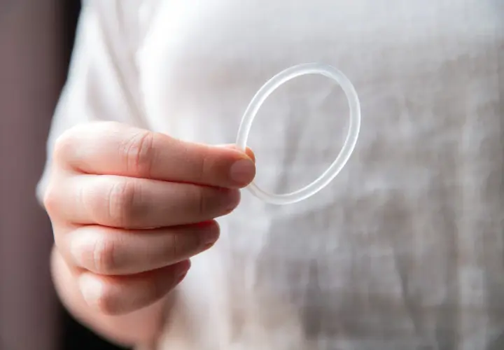 Dłoń trzyma przezroczysty ring dopochwowy.