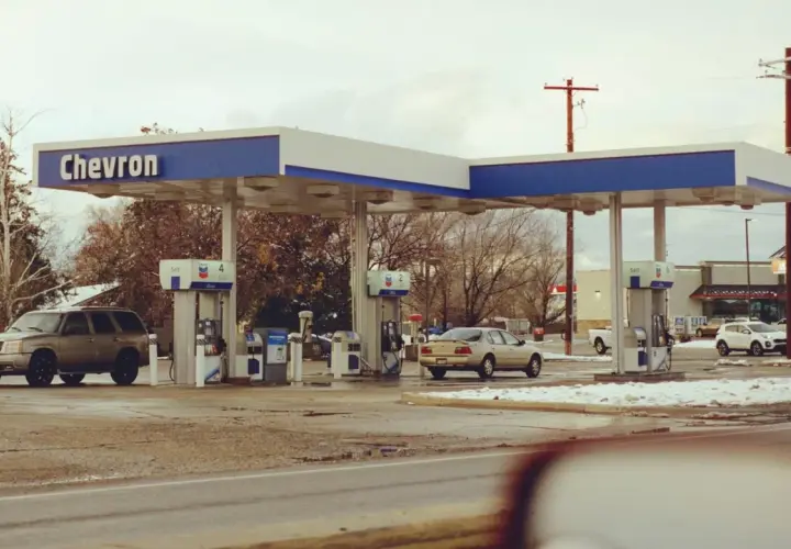 Stacja Chevron, samochody na zimowym parkingu. Zastanawiasz się, ile kosztuje jeden galon benzyny w USA?