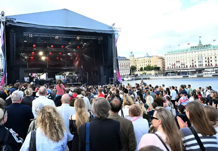 Stor publik njuter av en utomhuskonsert vid vattnet under ett kultur festival.