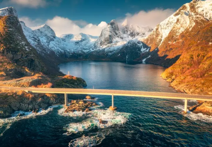 Mosty nad fiordem, ośnieżone góry, złote światło. Idealny czas na podróż do Norwegii to jesień, kiedy krajobraz jest tak piękny.