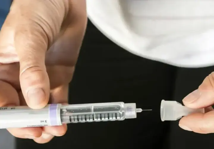 Dłoń przygotowuje pen do podania insuliny, kluczowy element w leczeniu cukrzycy typu 2.
