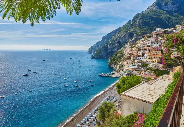 Positano, un luogo perfetto per un weekend con bambini in Campania. Case colorate aggrappate alla scogliera, mare blu e spiaggia animata.