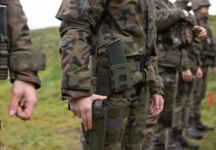 Żołnierze w mundurach polowych, gotowi do służby. Wiek poborowy w Polsce to czas przygotowania do obrony kraju.