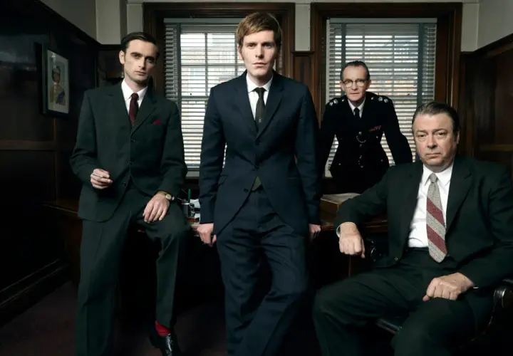 Fyra män i kostym och uniform står i ett kontor. En ung kommissarie Morse ser fundersam ut.
