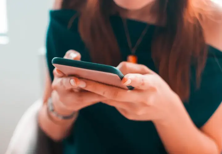 Kobieta pisze na telefonie, planując zakupy na Vinted z opcją PayPo.