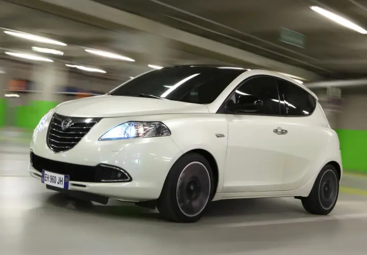 Lancia Ypsilon a metano in movimento in un parcheggio.