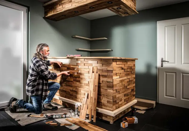 Mann baut mit Holzstücken eine einzigartige Bar. Heimwerken: bar selber bauen mit Stil.
