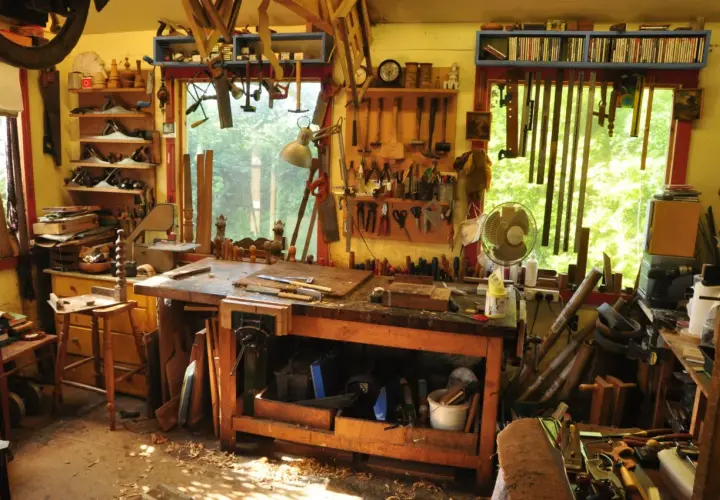 Un laboratorio pieno di attrezzi mostra come si lavora il legno: pialle, seghe, scalpelli e un banco da lavoro pronto per creare.