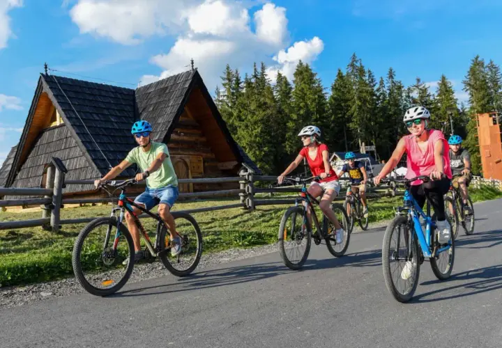 Rodzina cieszy się jazdą na rowerze po malowniczej trasie w Dolinie Chochołowskiej.