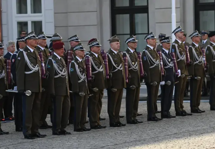 Uroczystość wręczenia nominacji na stopnie generalskie w Polsce. Wojskowi w galowych mundurach stoją w szeregu, prezentując swoje honory.