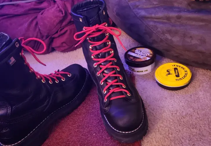 Black hiking boots with bright red laces, ready for adventure. Why do hiking boots have red laces? For a pop of color and to stand out on the trail!