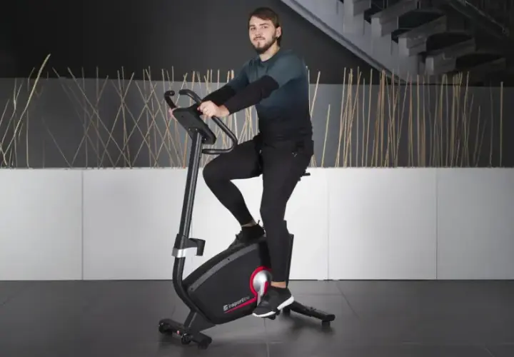 Mężczyzna ćwiczy na rowerze stacjonarnym, jednym z wielu rodzajów rowerów stacjonarnych dostępnych na rynku.