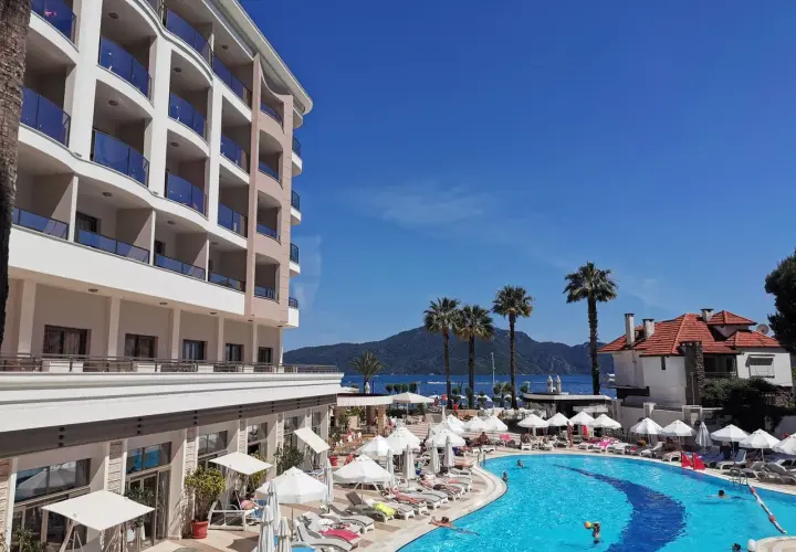 Fajny hotel nad morzem z basenem i palmami. Słoneczny dzień, idealny na wakacje.