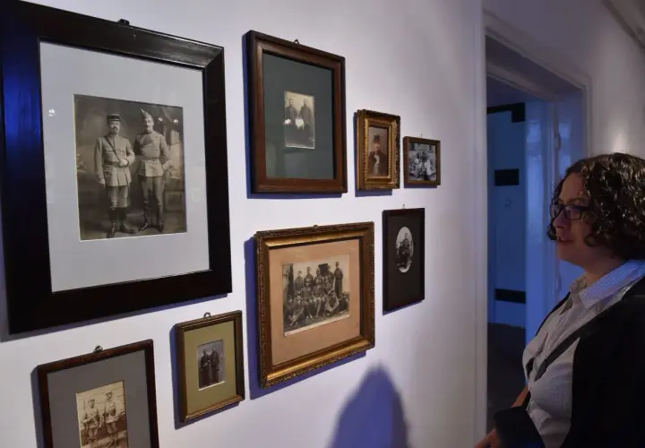 Kobieta ogląda galerię starych fotografii. Czy robienie komuś zdjęć jest karalne? W tym przypadku to historia uwieczniona na papierze.