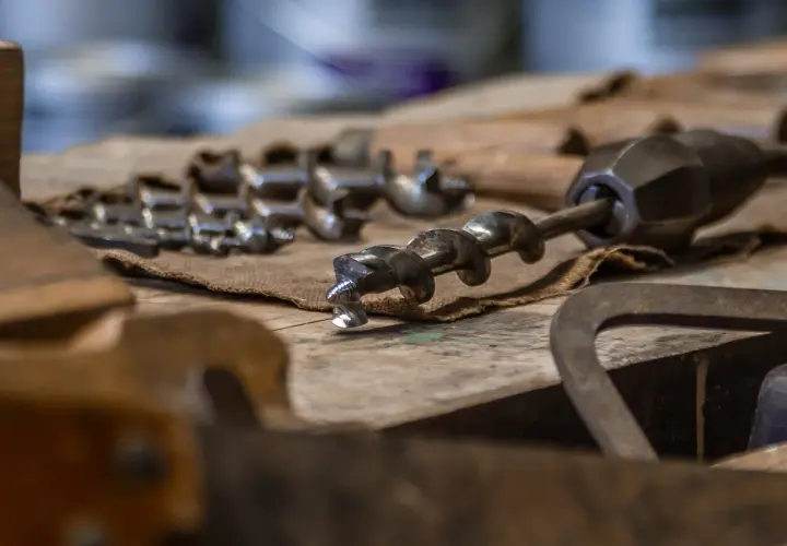 Utensili da falegnameria, tra cui punte elicoidali, per imparare come bucare il legno senza trapano.