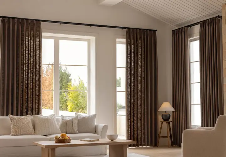 These rich brown curtains frame large windows, showing that curtains are far from out of style, adding warmth and texture to a modern living room.