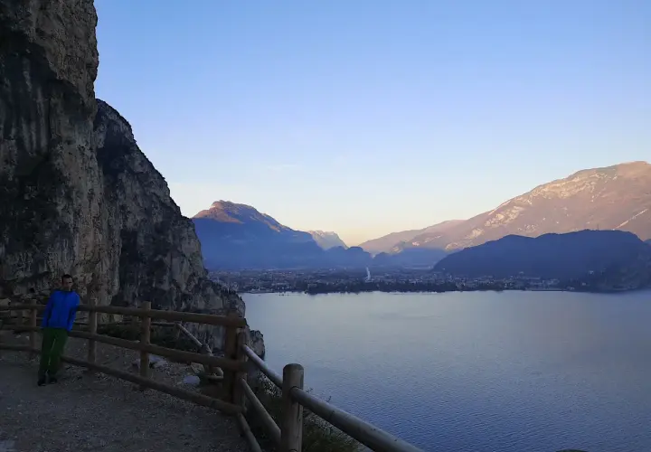 Spacer po ścieżce na zboczu Monte Brione z widokiem na jezioro i góry.
