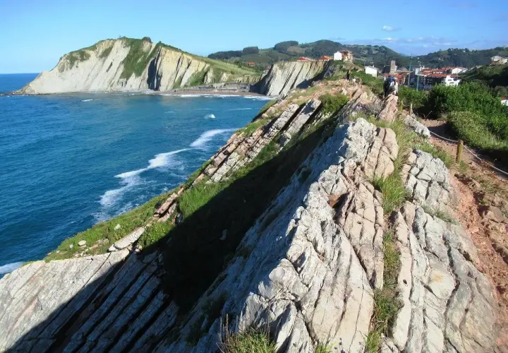 Acantilados vascos, como los de "Ocho Apellidos Vascos", con el mar azul y un sendero rocoso.