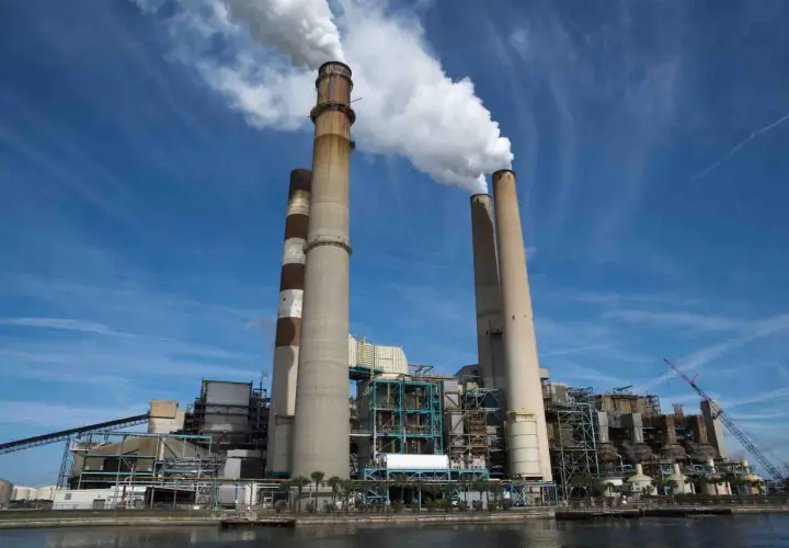 Chimeneas de una central eléctrica emiten vapor, un signo del calor industrial que genera energía.