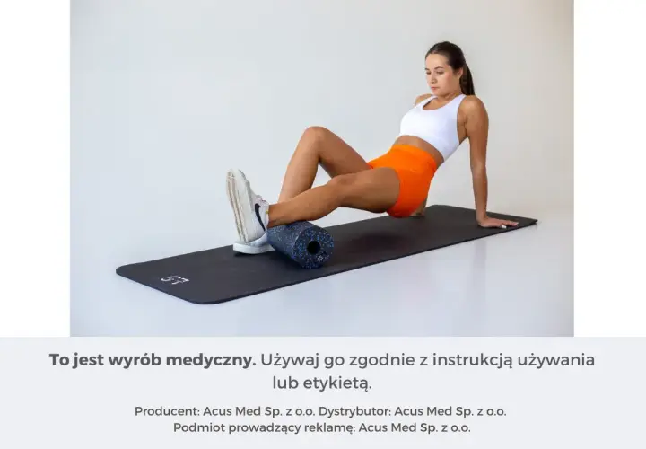 Kobieta wykonuje rolowanie po treningu, masując łydkę wałkiem na macie.