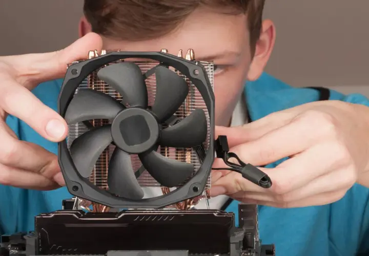 Junge Person montiert CPU-Kühler. Möglicher Fehler: cpu fan speed detection error.