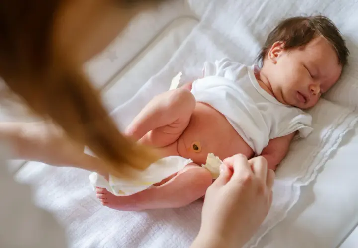 Nowy pępek maluszka po odpadnięciu kikuta pępowinowego, lekko zaczerwieniony, ale już zdrowiejący.