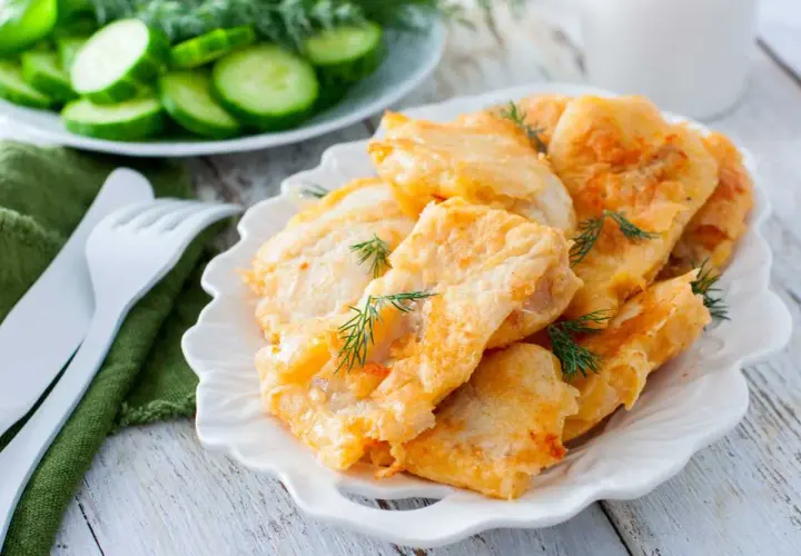 Deliciosa merluza rebozada, crujiente por fuera y tierna por dentro, adornada con eneldo fresco. Acompañada de rodajas de pepino.