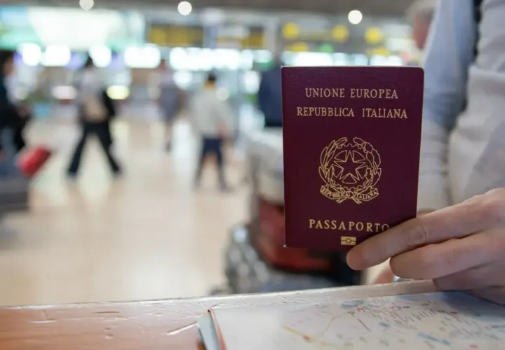 Włoski paszport w dłoni, gotowy do podróży po krajach bez paszportu w strefie Schengen.