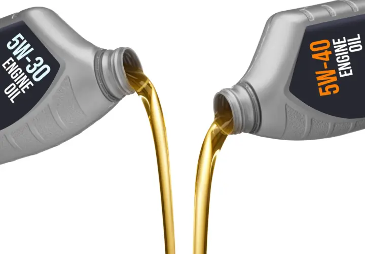 Aceite 5w30 vs 5w40: dos botellas vierten aceite dorado, mostrando la diferencia de viscosidad.