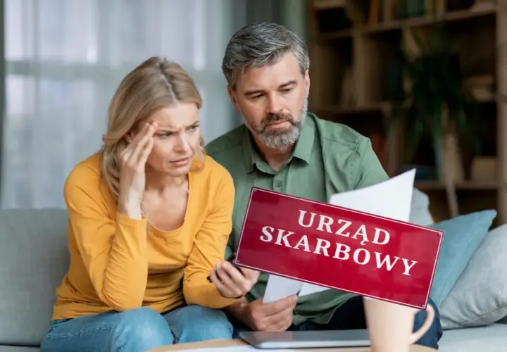 Para martwi się o pieniądze z wesela na konto. Na stole leży tabliczka "Urząd Skarbowy", a kobieta trzyma się za głowę.