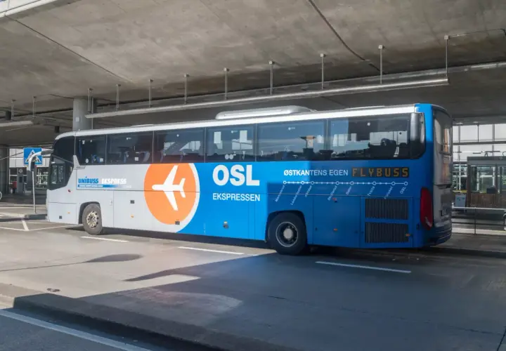 Autobus Flybuss OSL z logo samolotu, gotowy do odjazdu z lotniska Oslo.