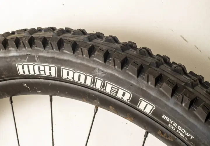 Close-up of a Maxxis High Roller II tire, ready for a review. Its aggressive tread promises excellent grip on challenging trails.