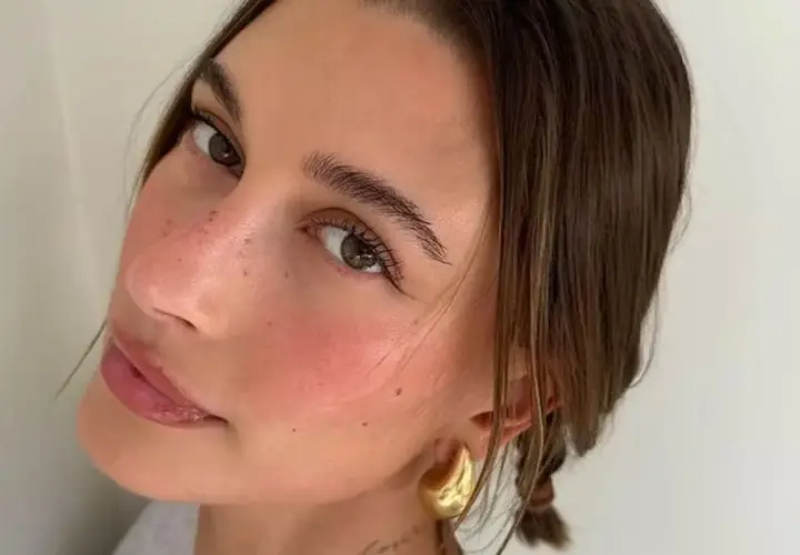 En närbild på en kvinna som har valt att applicera rouge för en naturlig, rosig look.