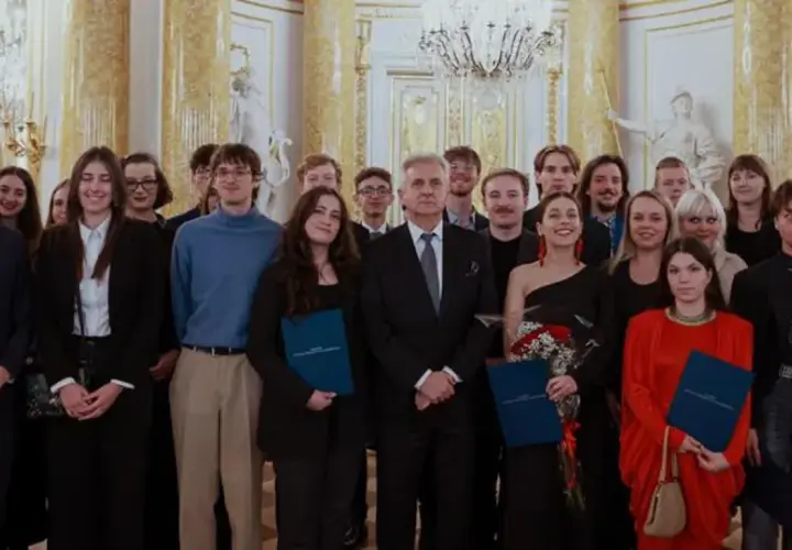 Grupa młodych ludzi w eleganckich strojach odbiera stypendium artystyczne ministra kultury.